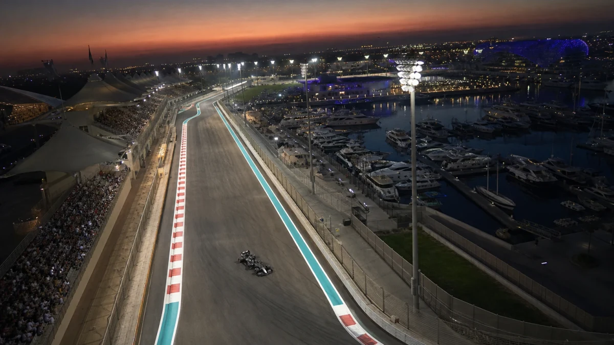 F1-bil på Yas Marina i skymning med upplyst depåbyggnad