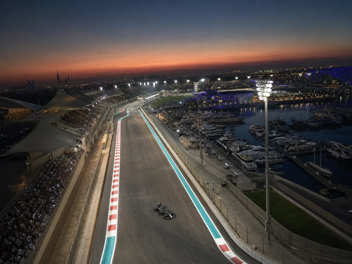 F1-bil på Yas Marina i skymning med upplyst depåbyggnad
