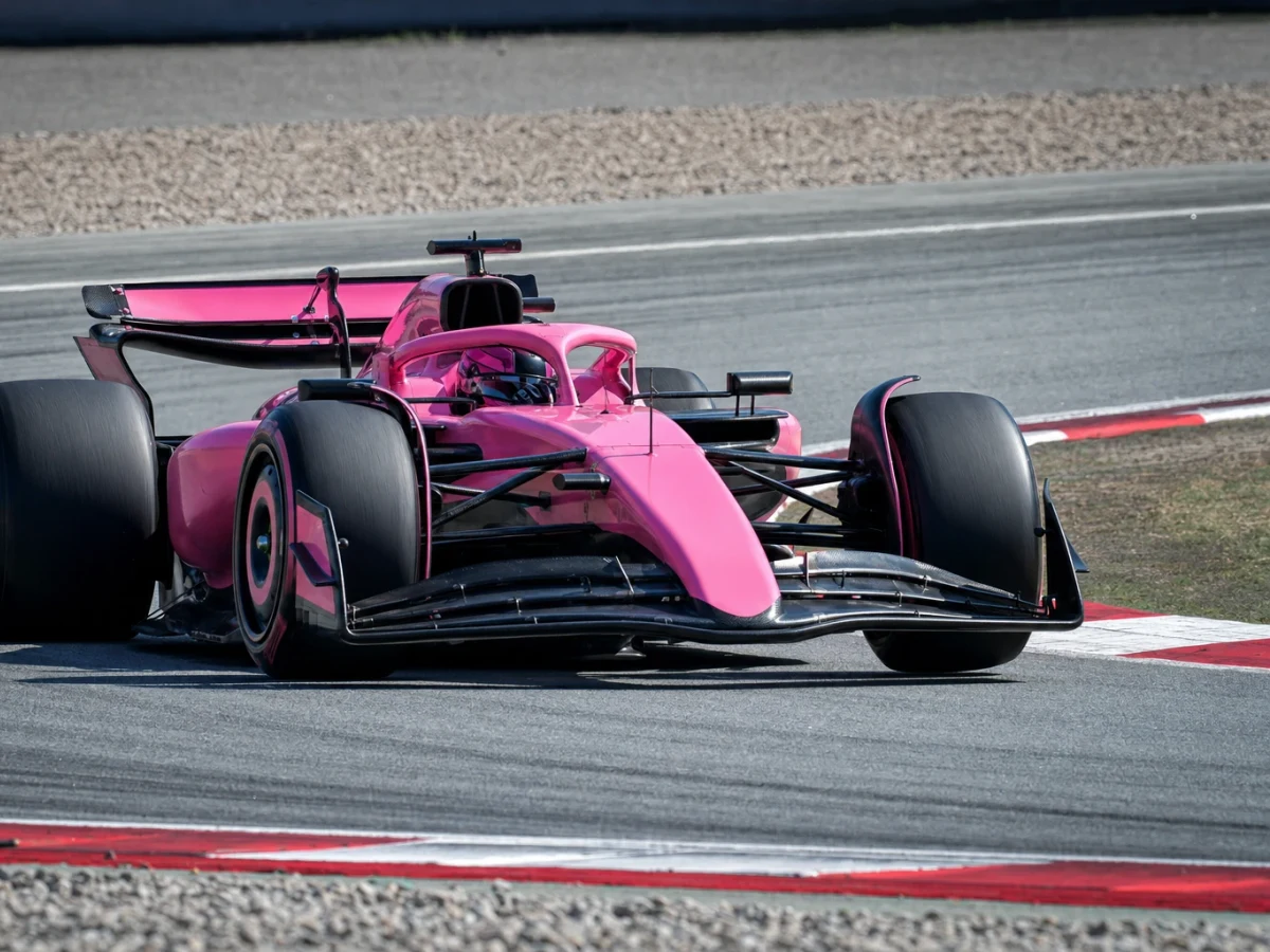 En rosafärgad Formel 1-bil på banan under en träning.