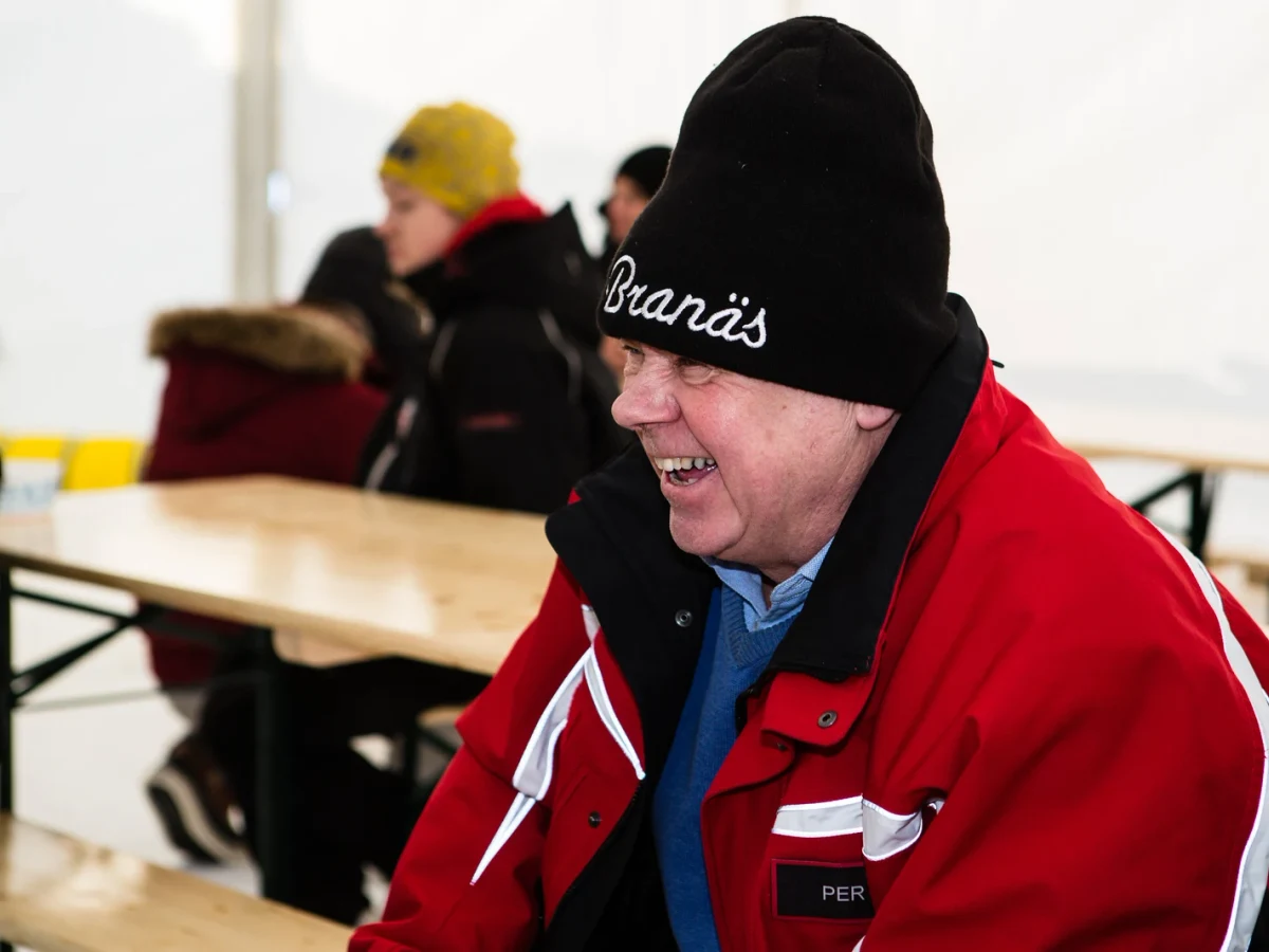 Rallybil som sladdar upp ett grusmoln på en skogsväg.